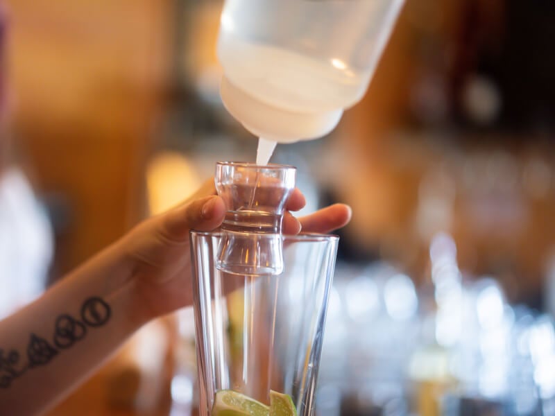 woman pouring sugar syrup into glass